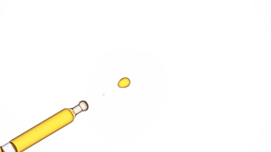 Drop of jojoba oil is dripped from pipette