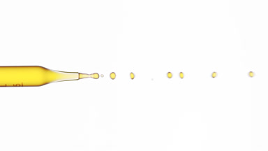 Yellow fluid flows from graduated lab dropper