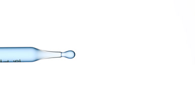 Blue fluid is dripped from graduated lab pipette