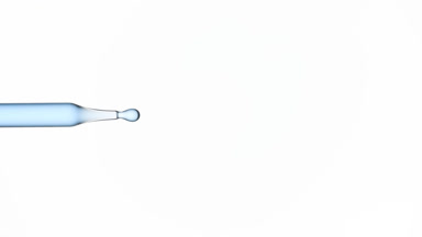 Drops of blue transparent fluid are dripped from dropper