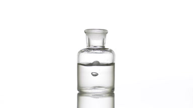 Drop falling into old fashioned bottle with clear liquid