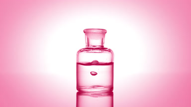 Drop falling into old fashioned bottle with clear liquid