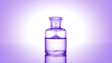 Drop falling into old fashioned bottle with clear liquid