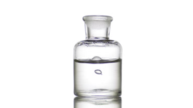 Drop falling into old fashioned bottle with clear fluid