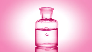 Drop falling into old fashioned bottle with clear fluid