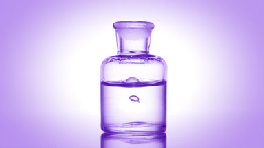 Drop falling into old fashioned bottle with clear fluid