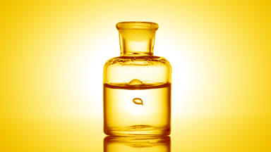 Drop falling into old fashioned bottle with clear fluid