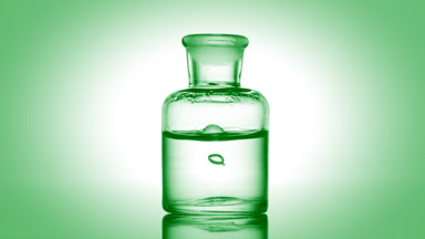 Drop falling into old fashioned bottle with clear fluid
