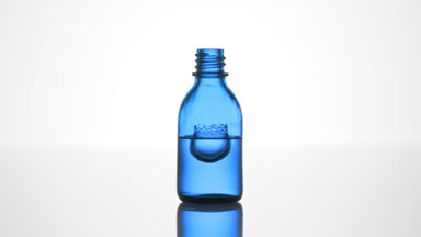Drop falls into blue medical bottle with liquid creating splash