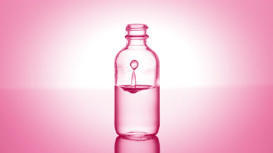 Lactic acid falls down into medical bottle with pink liquid