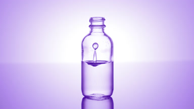 Salicylic acid falls down into medical bottle with purple liquid
