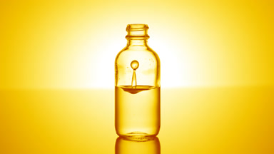 Ascorbic acid falls down into medical bottle with yellow liquid