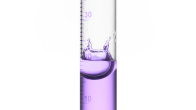 Drop of purple fluid is falling down into graduated cylinder