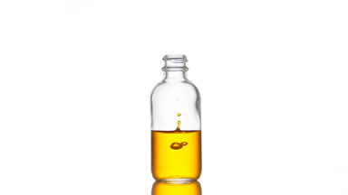 Vitamin C is falling down into medical bottle with yellow liquid