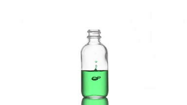 Vitamin K is falling down into medical bottle with green liquid