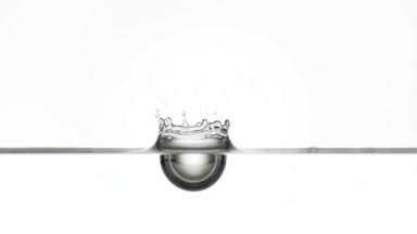 Grey drop falls down on grey liquid surface creating ripples