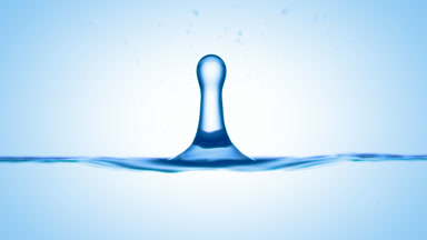 Drop of watermelon extract falls on blue liquid creating ripples