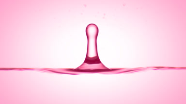 Drop of pomegranate extract falls on liquid creating ripples