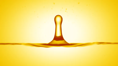 Drop of almond extract falls on yellow liquid creating ripples