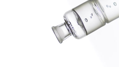 Hyaluronic acid drips into old fashioned bottle with grey liquid