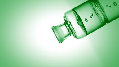 Citric acid drips into old fashioned bottle with green liquid