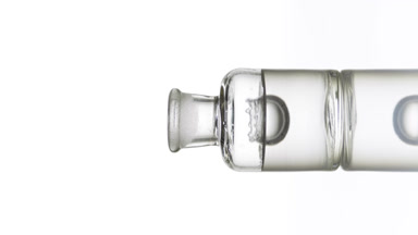 Drop falling into old fashioned bottle with transparent liquid