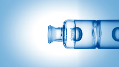 Drop falling into old fashioned bottle with transparent liquid