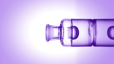 Drop falling into old fashioned bottle with transparent liquid