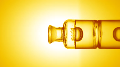 Drop falling into old fashioned bottle with transparent liquid