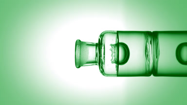 Drop falling into old fashioned bottle with transparent liquid
