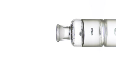 Drop of hyaluronic acid falls into bottle with grey fluid