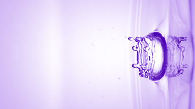 Violet drop falls on surface of clear liquid creating circles