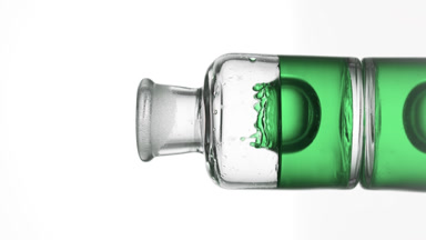 Drop of eucalyptus oil is falling down into old fashioned bottle