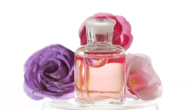 Drop of eustoma extract falls into bottle in front of eustomas