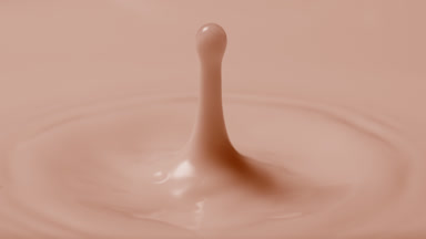 Brown milk drop falls on brown milk surface creating circles