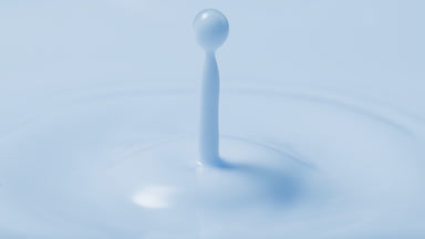 Blue milk drop is falling on blue milk surface creating circles