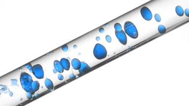 Blue tansy oil is pouring into glass tube with clear liquid