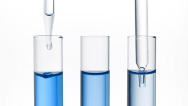 Clear fluid is dripped from dropper into one of three test tubes