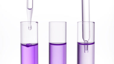 Clear fluid is dripped from dropper into one of three test tubes