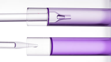 Lab dropper takes purple liquid from test tube and drips it back