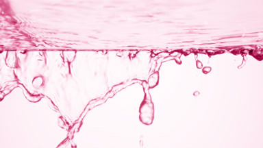 Pink fluid is flowing from glass surface on pale pink background