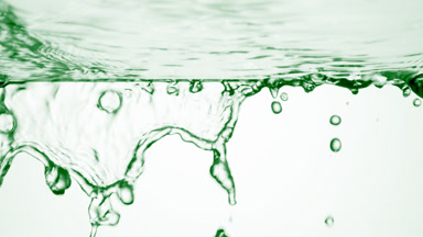 Green fluid is flowing from glass surface on green background