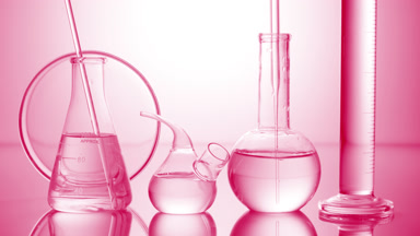 Long dropper is lowered into flask surrounded by lab glassware