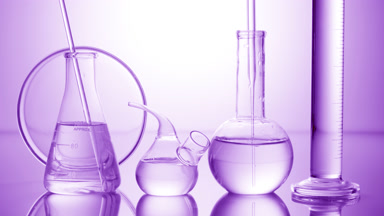 Long dropper is lowered into flask surrounded by lab glassware