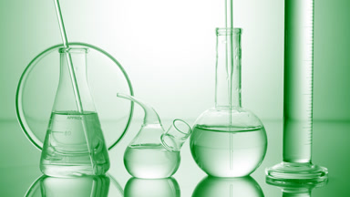 Long dropper is lowered into flask surrounded by lab glassware