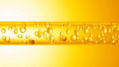 Different sized bubbles flowing in glass tube with clear liquid