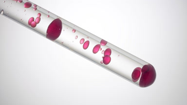 Red liquid is pouring in test tube with transparent one
