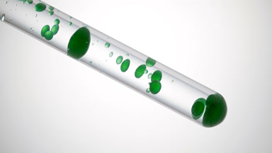 Green liquid is pouring in test tube with transparent one