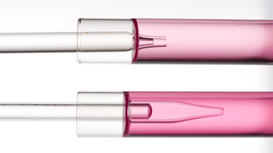 Lab dropper takes pink liquid from test tube and drips it back