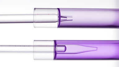 Lab dropper takes purple liquid from test tube and drips it back